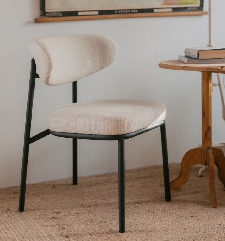 Silla tapizada de estilo moderno minimalista con estructura metálica negra y tejido beige en comedor contemporáneo