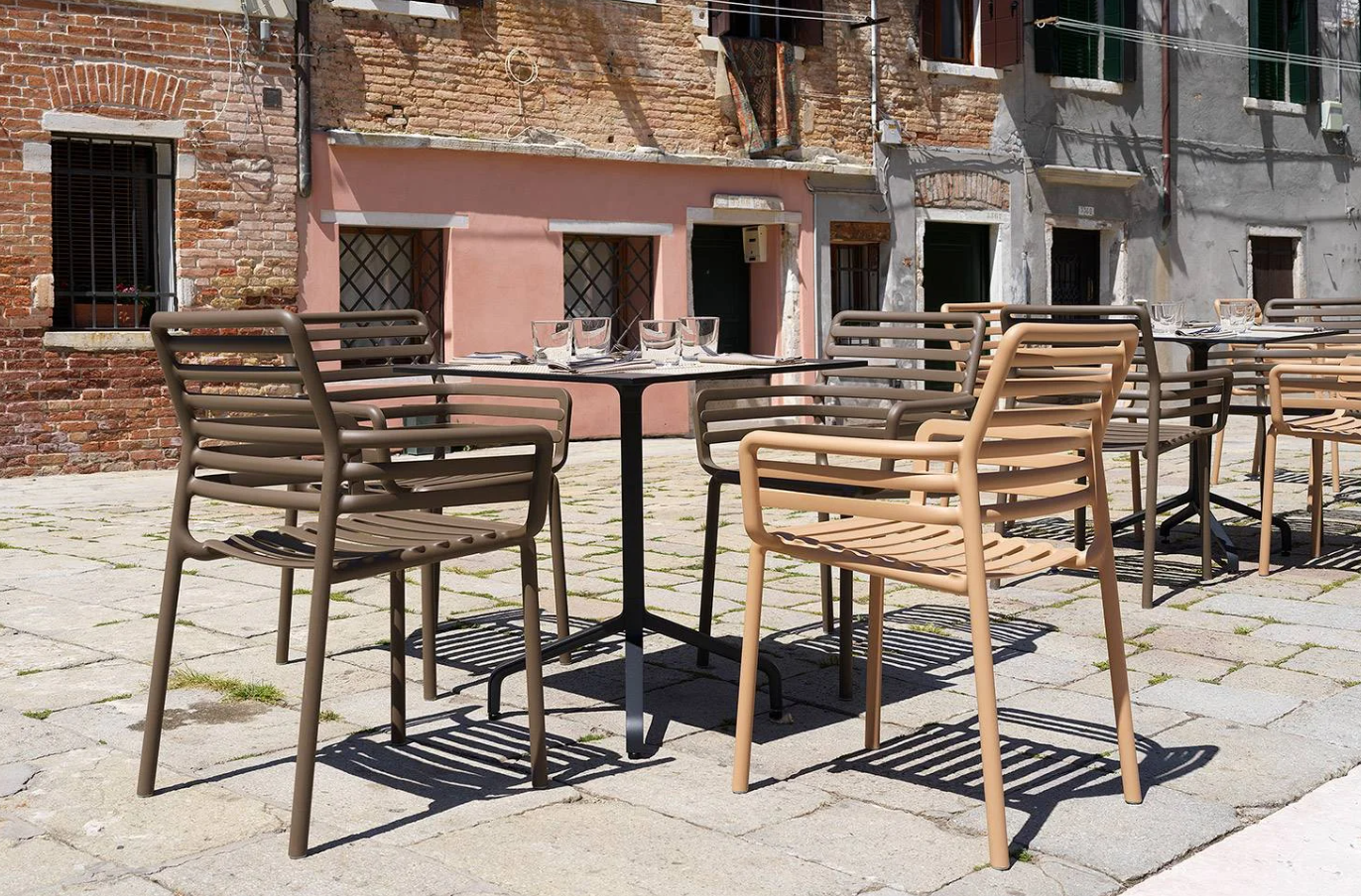 Silla Doga Armchair con mesa Clip en una terraza de bar